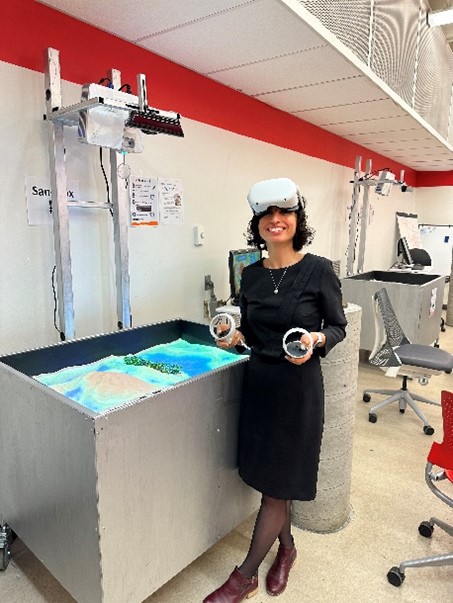 Mojgan Jadidi demonstrating an immersive sandbox while wearing a VR headset