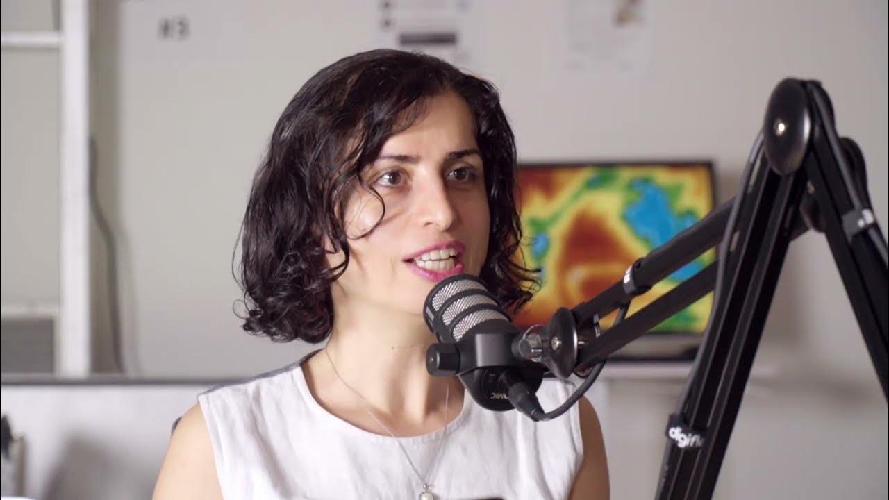 Mojgan Jadidi speaking into a microphone during a podcast recording